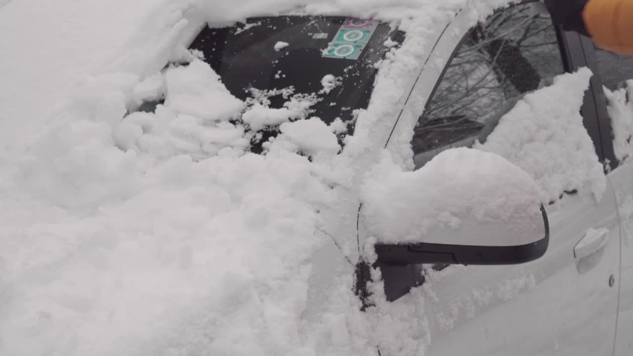 用刷子清理汽车挡风玻璃上的积雪视频素材