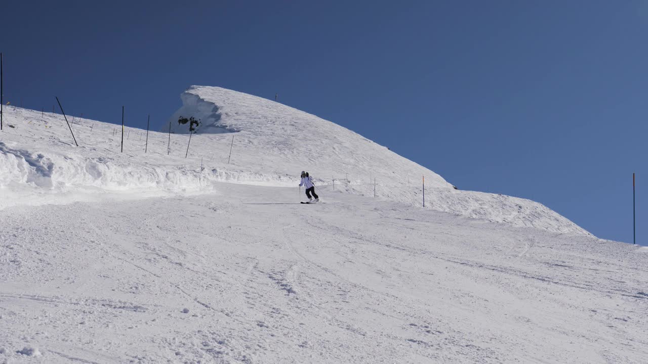 滑雪者在阳光明媚的冬日在雪山滑雪视频素材