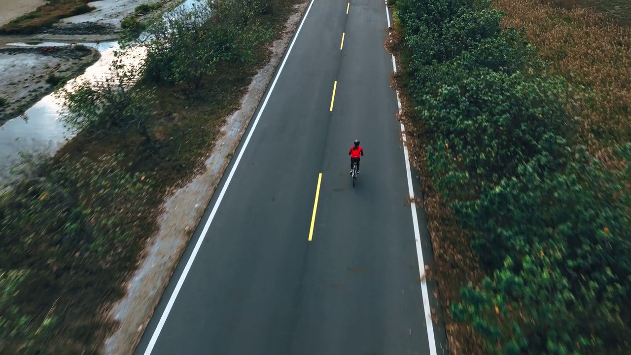 骑自行车公路旅行与女运动员骑手在早晨无人机视图视频素材