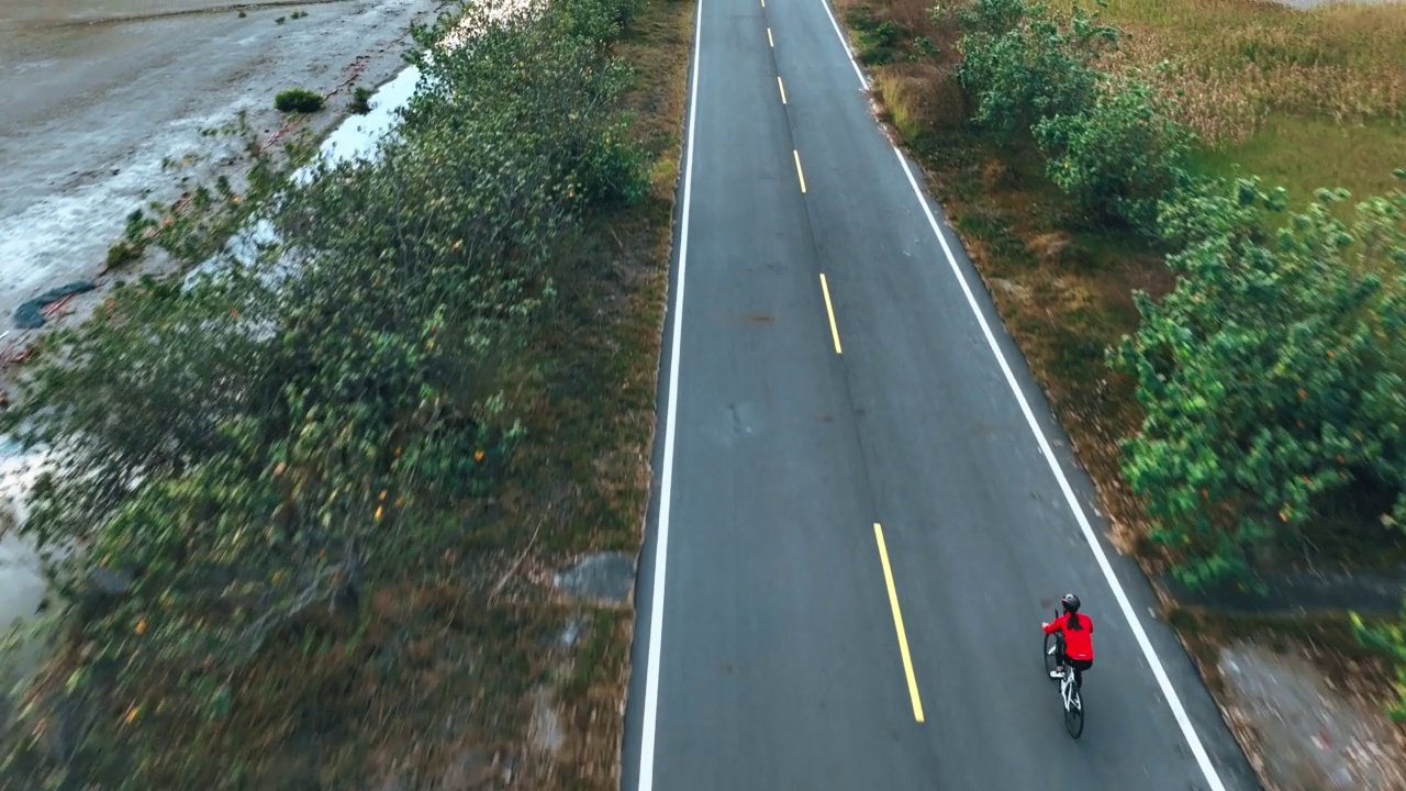 骑自行车公路旅行与女运动员骑手在早晨无人机视图视频素材