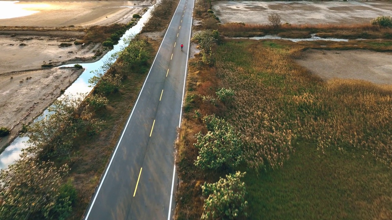 自行车骑公路旅行与女运动员骑手在早上无人机视图视频素材