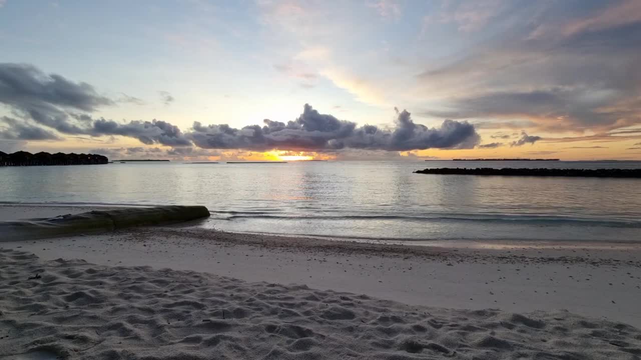 女人在浴袍散步和跳舞在热带海滩附近的海洋在黄昏日落日出时间，时间流逝的视频，在度假胜地享受假期视频下载