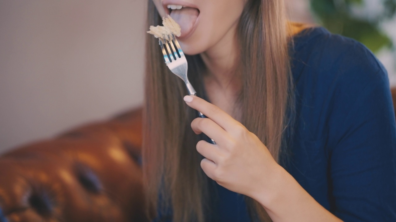 年轻女子在餐厅里吃着蛋糕，喝着茶，闲暇时光视频素材