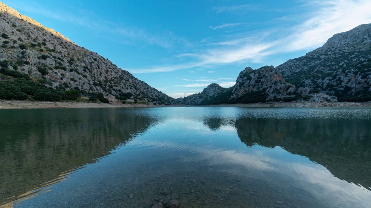 山与山之间的湖泊，日出时地平线上有一些云流动。视频素材