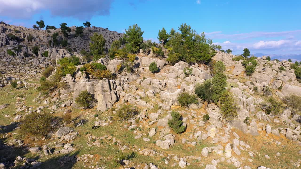 风景秀丽的山峦景观，以岩层和绿色的树木为背景，蓝天。视频素材