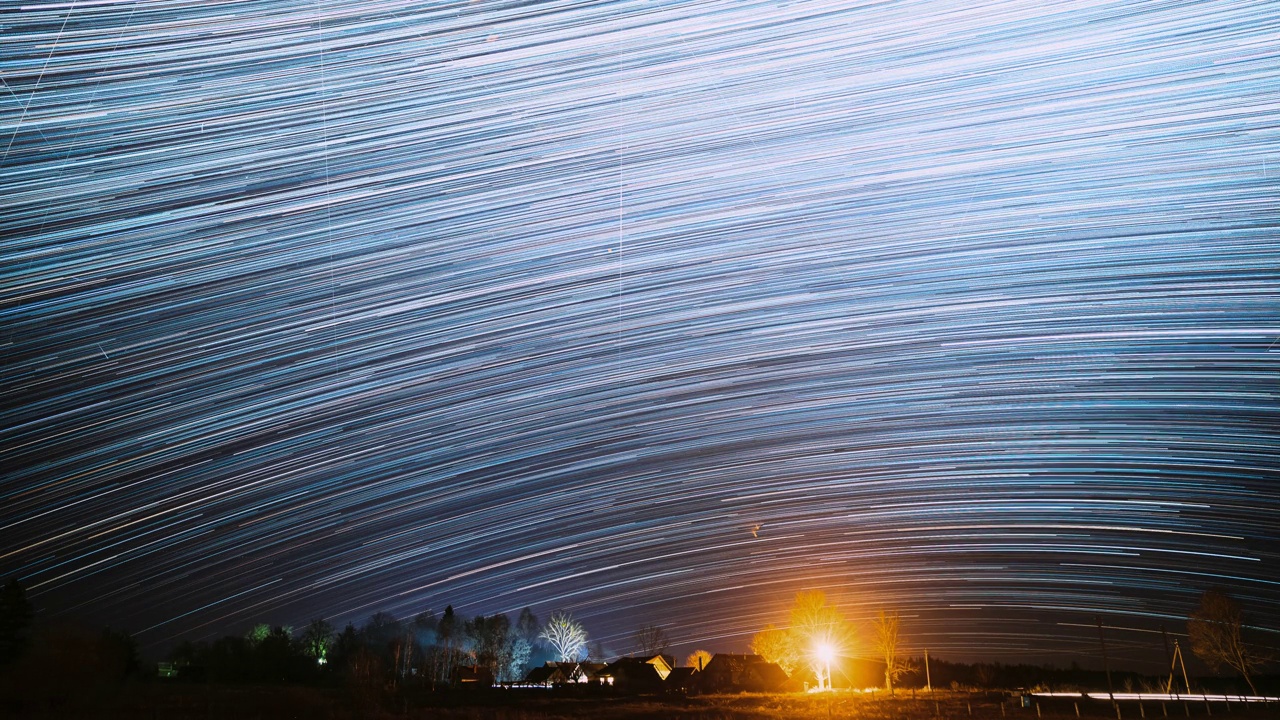 4k时间间隔夜星空上方的村庄。天空背景的乡村乡村景观。流星划过深蓝色的天空。惊人的不寻常的星星效果。明亮的蓝色。延时，延时视频素材