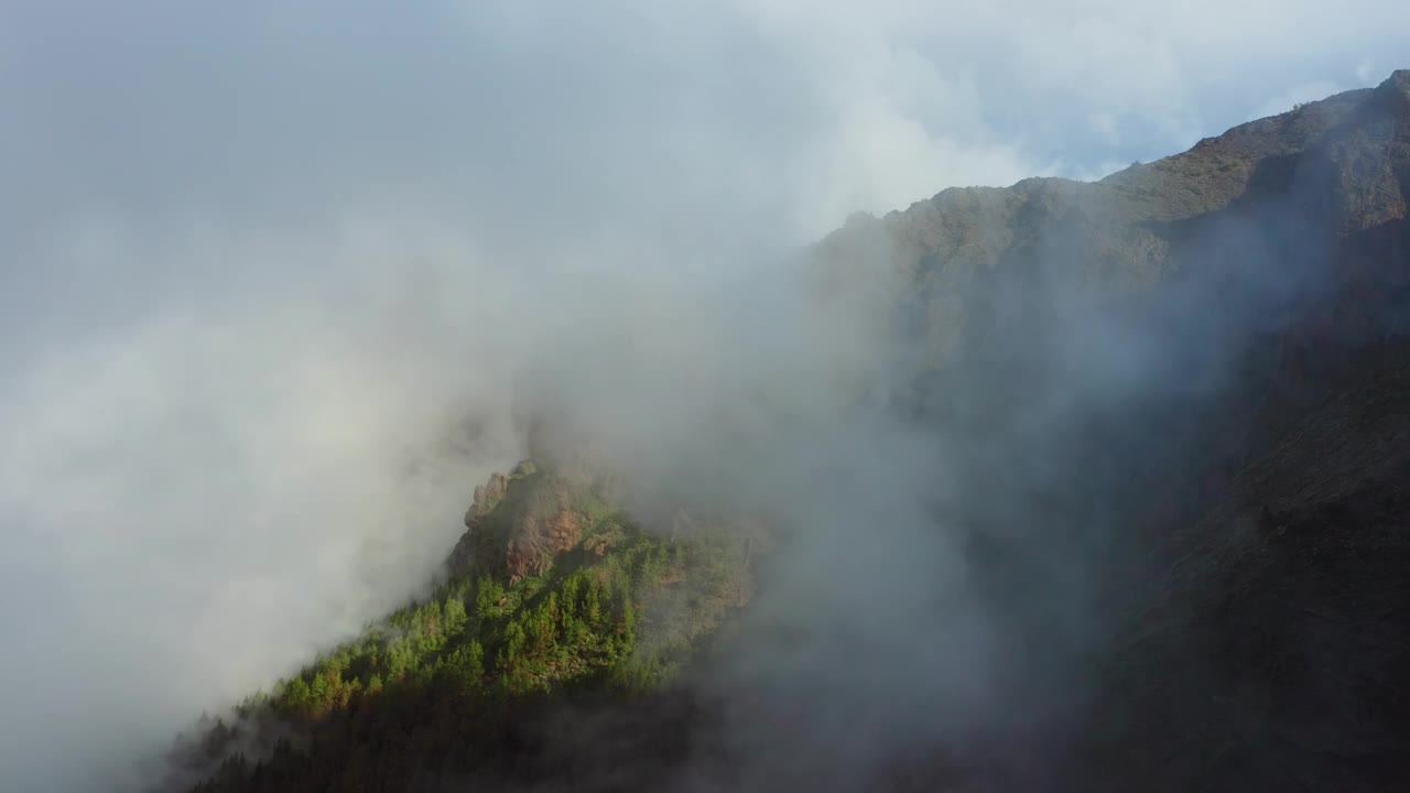 雾云迅速从山腰下降到峡谷针叶林。美丽的山峰在雾霾。阳光明媚的冬日，特内里费岛的泰德国家公园。视频素材