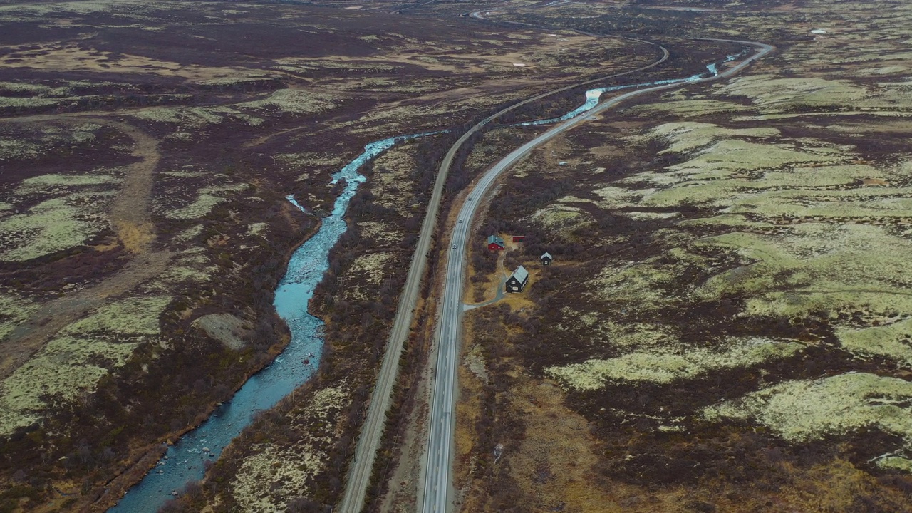 在挪威苔原上，汽车行驶在风景优美的弯曲山区公路上的鸟瞰图视频素材