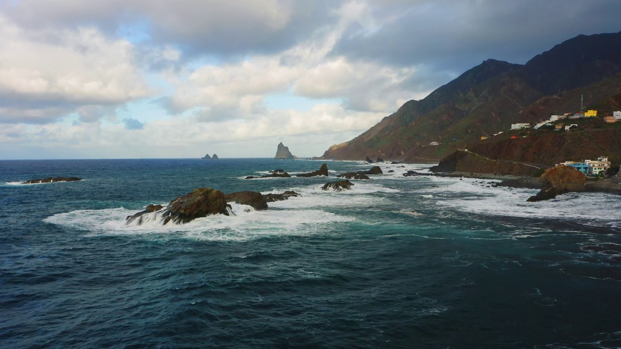 雄伟的黑沙岩石海岸线贝尼霍海滩在特内里费加那利群岛。大海中美丽的巨浪撞击着岩石。Almaciga村庄。晚上自然。视频素材