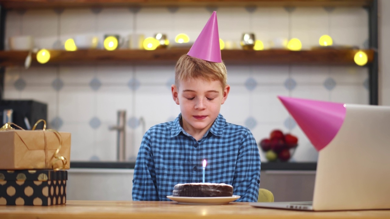 一个十几岁的男孩独自在家网上庆祝生日。实时视频素材