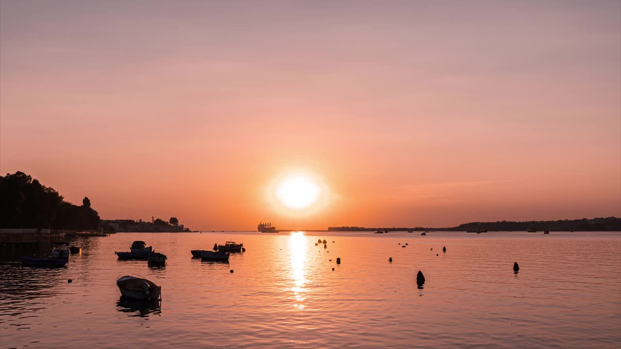 时间流逝的港口生活与许多摩托艇，游轮和散货船，通过海湾在日落的背景视频下载