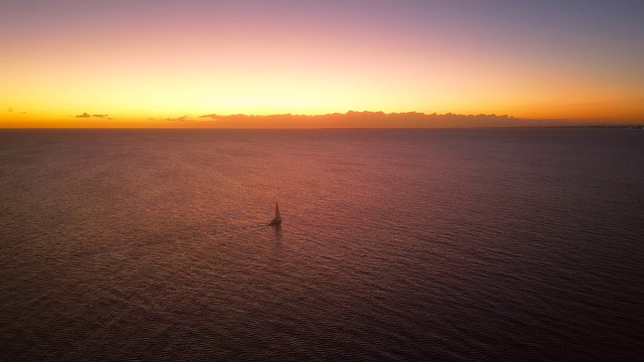 日落时海上帆船的鸟瞰图。浪漫的度假胜地。美丽的粉红色海景。视频素材