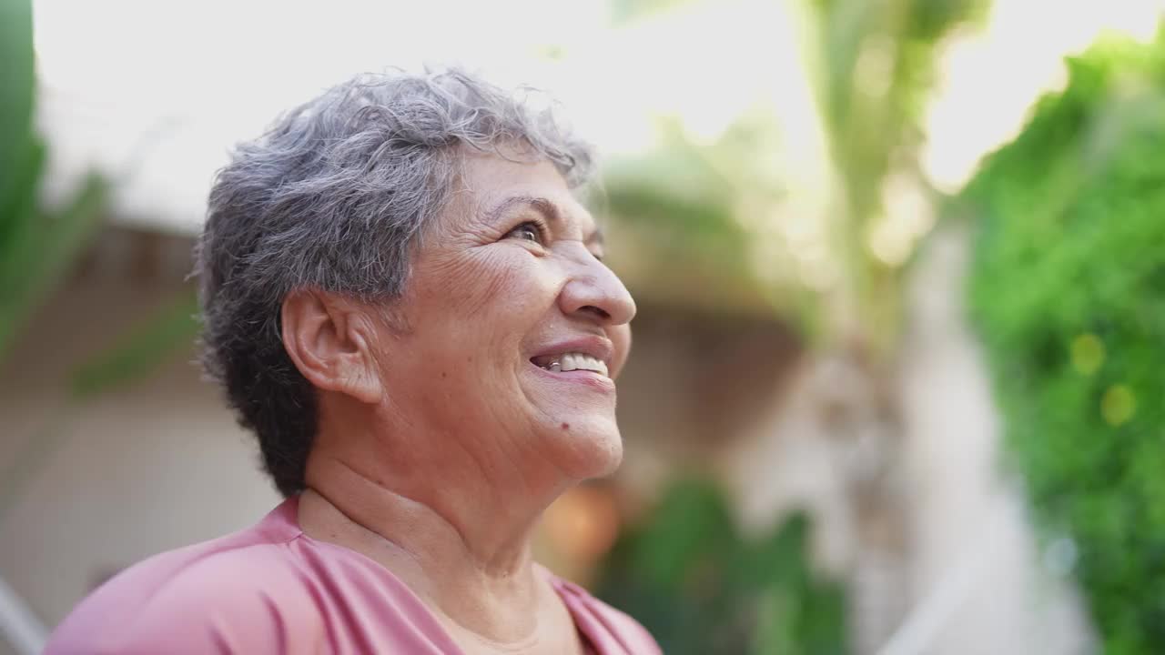 一位年长的女士望向远方，凝视着户外视频素材