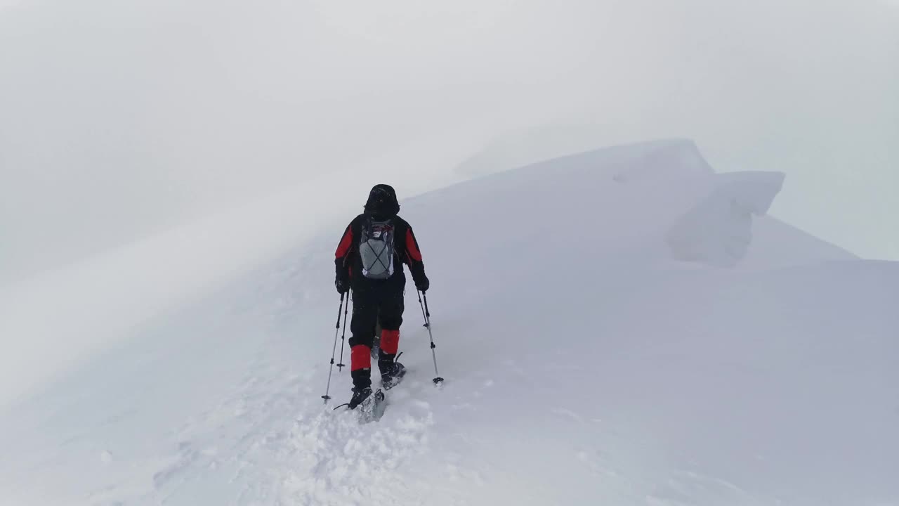 两名徒步旅行者通过了一段危险的小道——积雪的岩壁。视频素材