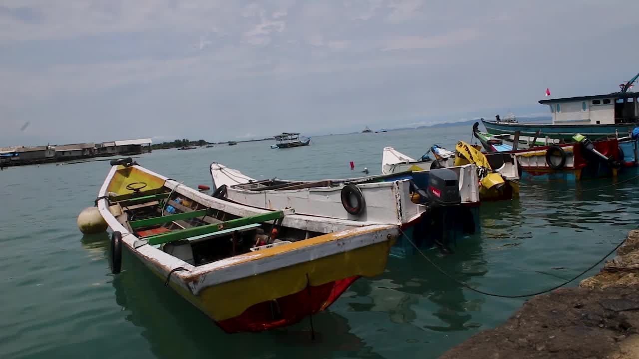 白天的景色，几艘传统渔船倚在海滩上视频素材