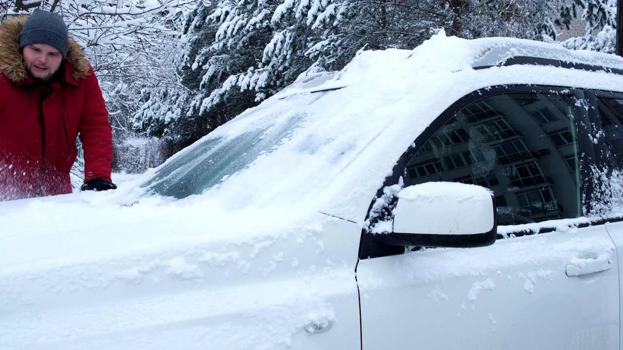 男人正在清理车上的雪视频素材