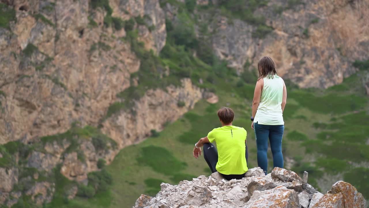 探索世界。一对男女站在山边，欣赏山景视频素材