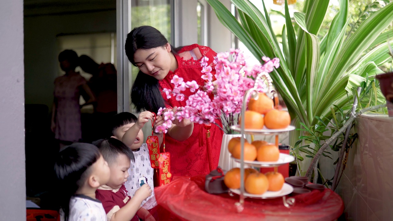 亚洲华人妇女和孩子们装饰他们的房子为中国新年视频素材