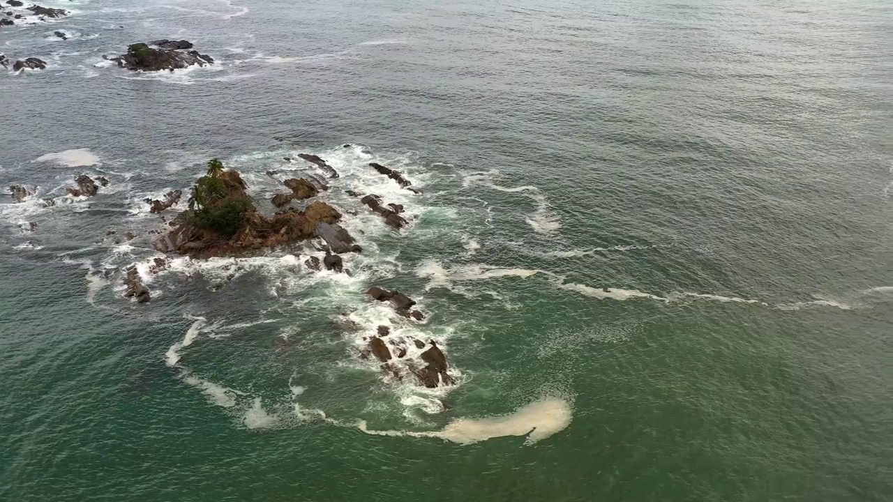 无人机在多米尼加冲浪海滩的岩石海岸线上空飞行，哥斯达黎加4K分辨率的拷贝空间视频素材