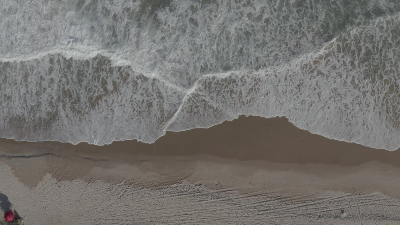 海浪在沙滩上轻轻破碎的俯视图视频下载