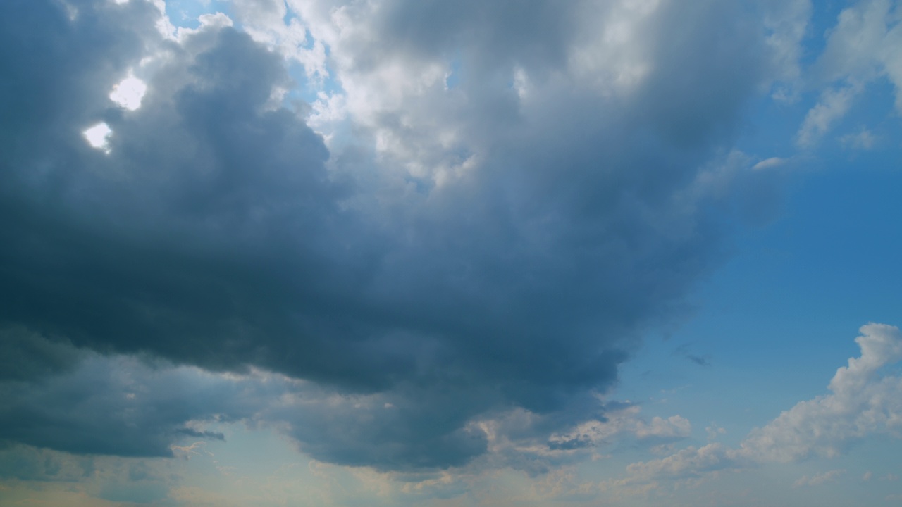 时间流逝。蓝天上飘着白色蓬松的雨云。戏剧性的云景，令人惊叹的天空。视频素材