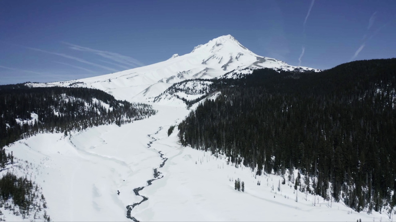 空中拍摄的落基山脉被白雪覆盖，背景是蓝天视频素材