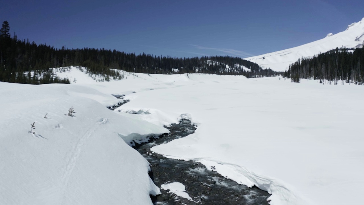 空中拍摄的落基山脉被白雪覆盖，背景是蓝天视频素材