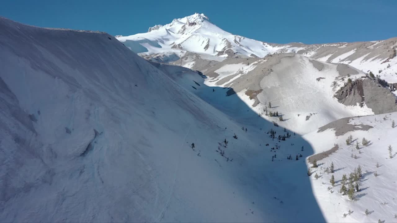 空中拍摄的落基山脉被白雪覆盖，背景是蓝天视频素材