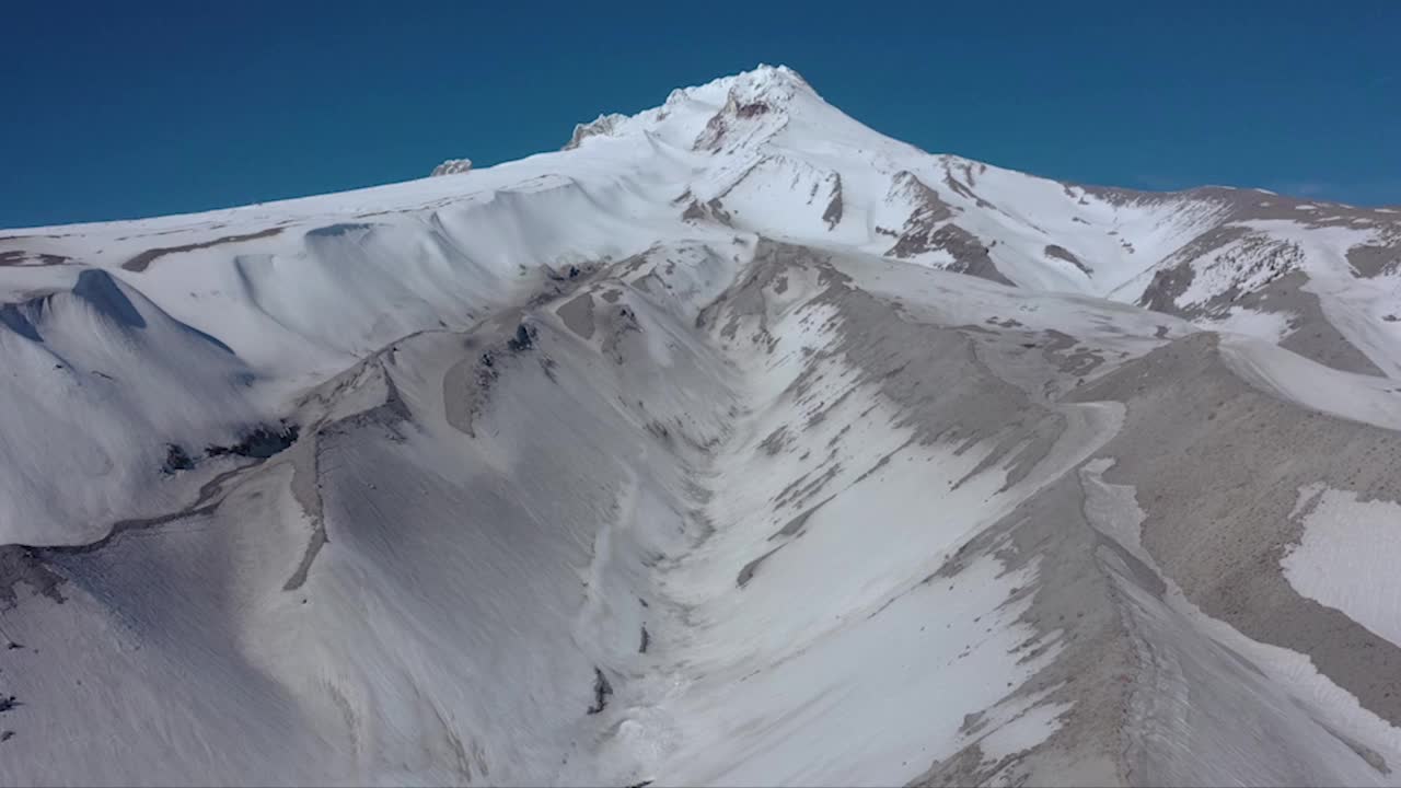 空中拍摄的落基山脉被白雪覆盖，背景是蓝天视频素材