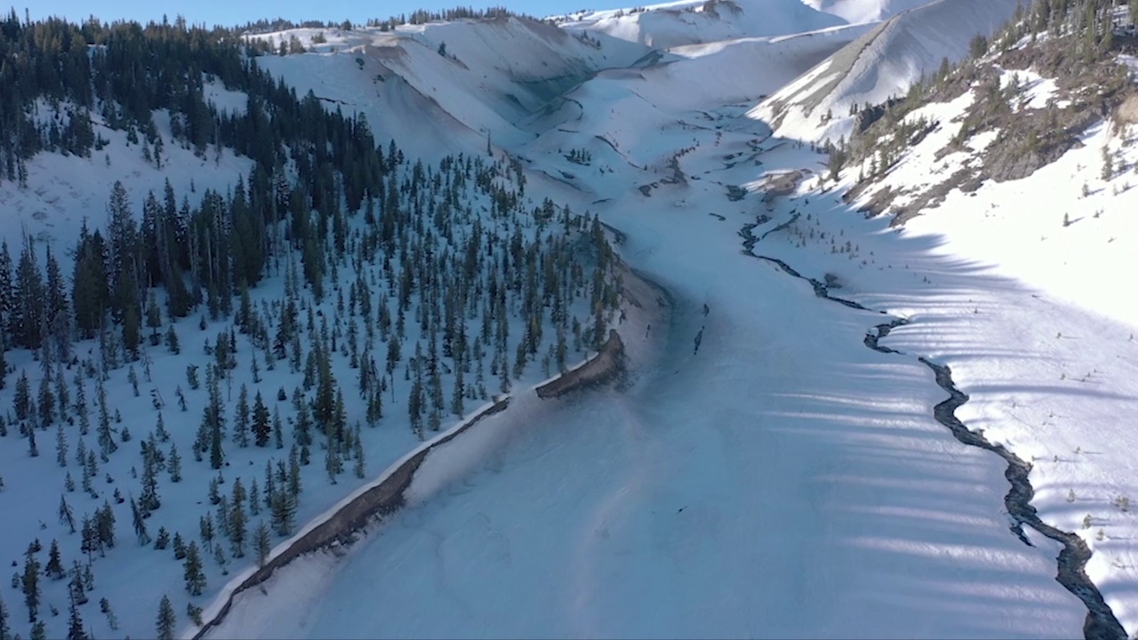 空中拍摄的落基山脉被白雪覆盖，背景是蓝天视频素材