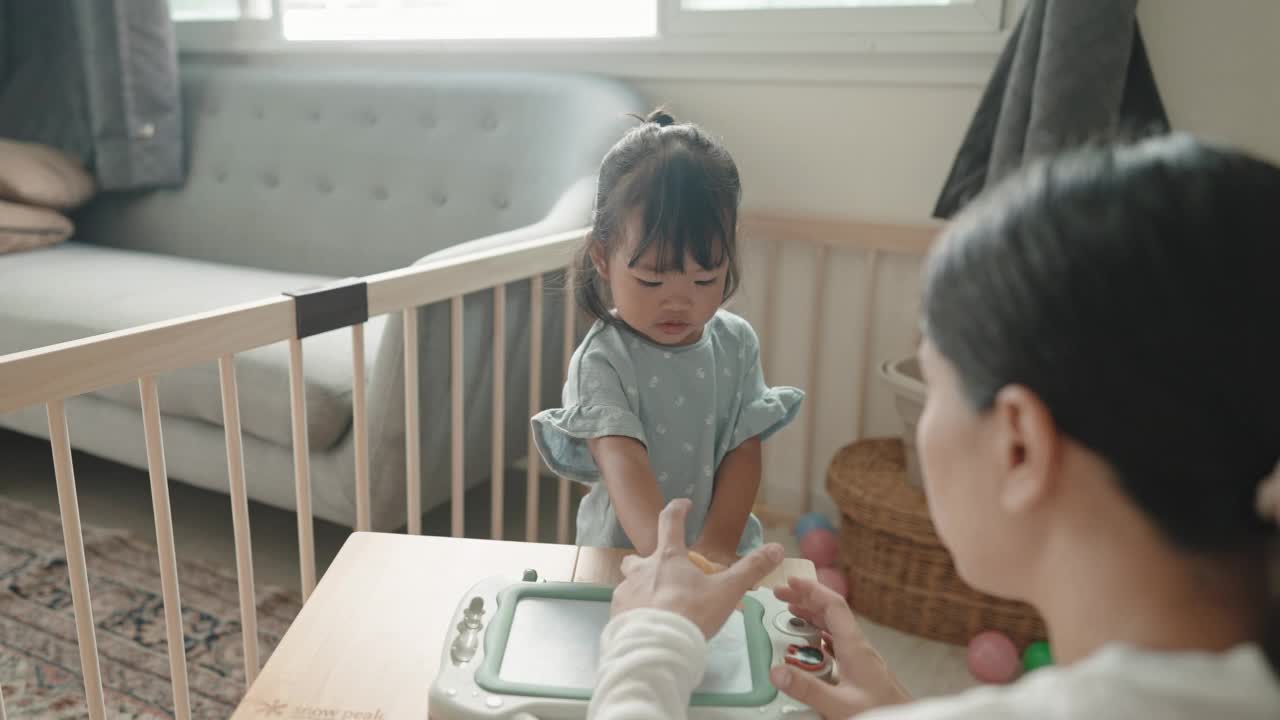 积极的情感亚洲女婴喜欢在家跟妈妈学画画蒙台梭利教育家庭生活理念视频素材