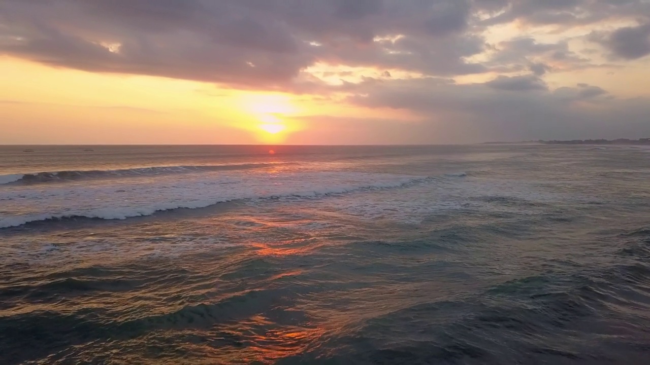 电影无人机镜头。夕阳在海浪上冲刷着沙滩。空中日落。热带无人自然海景。天堂巴厘岛，印度尼西亚，亚洲的海湾。视频素材