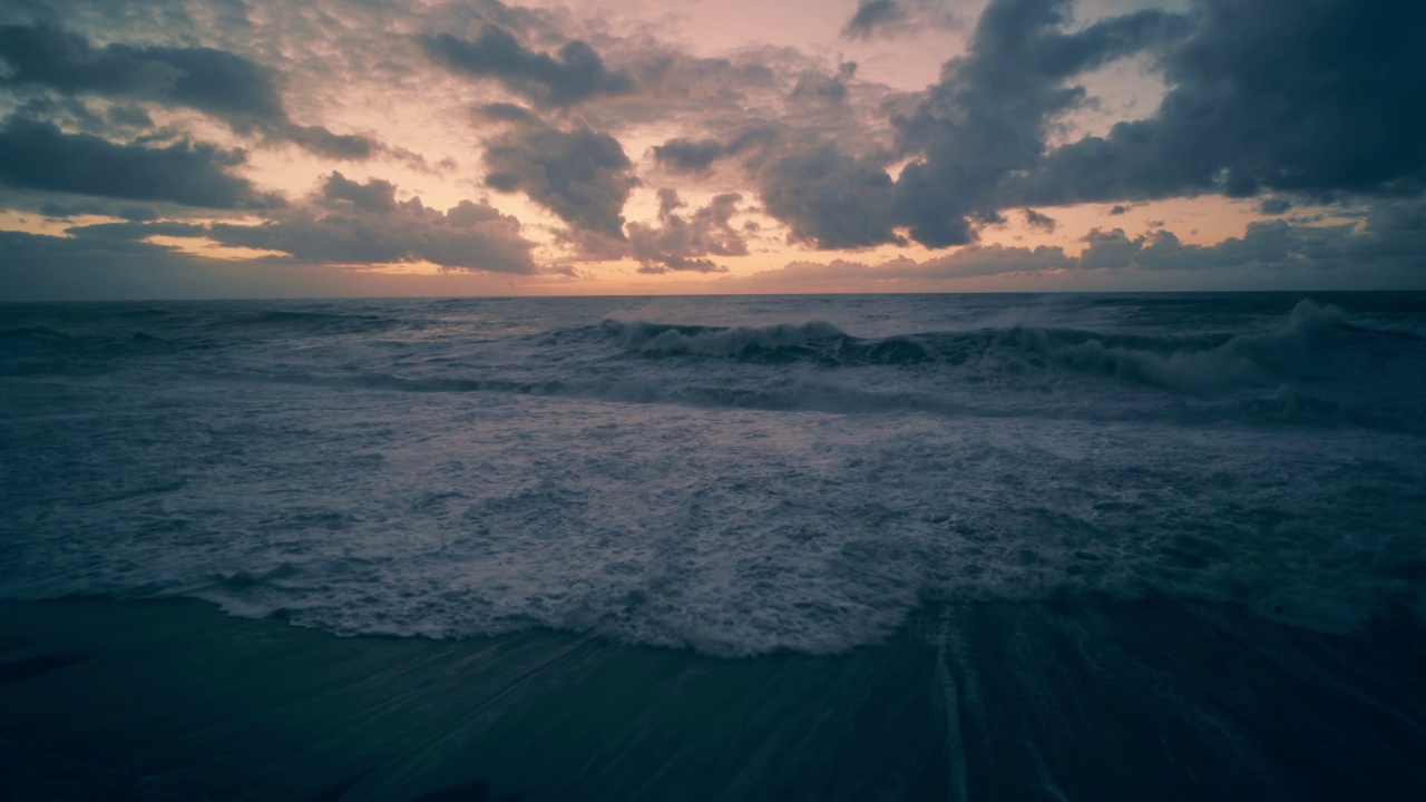 戏剧性的日落天空与云在海浪与泡沫在海岸线沙滩视频素材