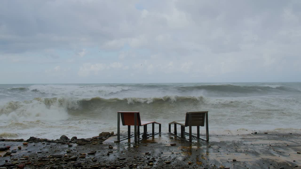 在极端的暴风雨天气中，海浪冲击着被摧毁的道路和海岸线视频素材