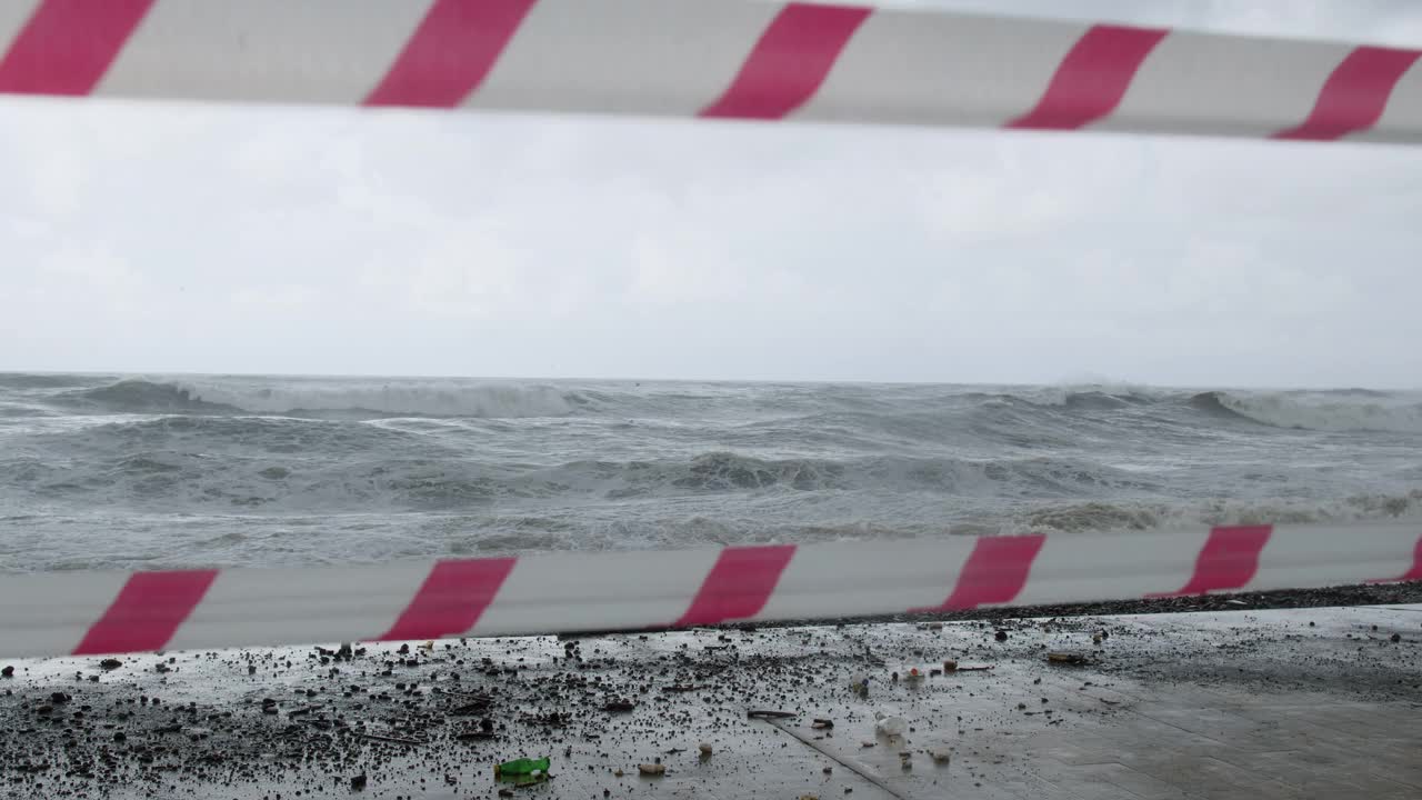 在极端的暴风雨天气中，海浪冲击着被摧毁的道路和海岸线视频素材