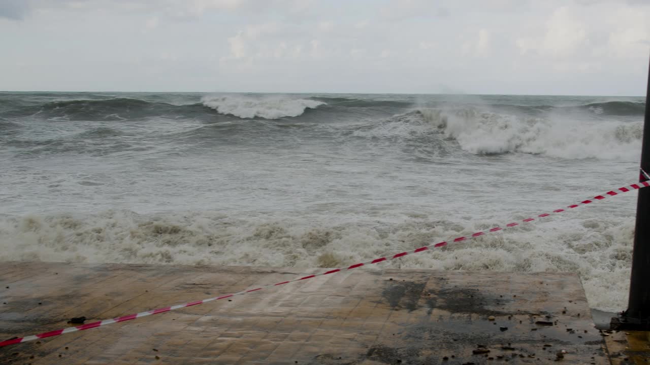 在极端的暴风雨天气中，海浪冲击着被摧毁的道路和海岸线视频素材