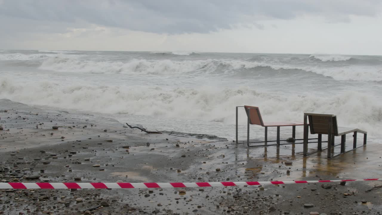 在极端的暴风雨天气中，海浪冲击着被摧毁的道路和海岸线视频素材