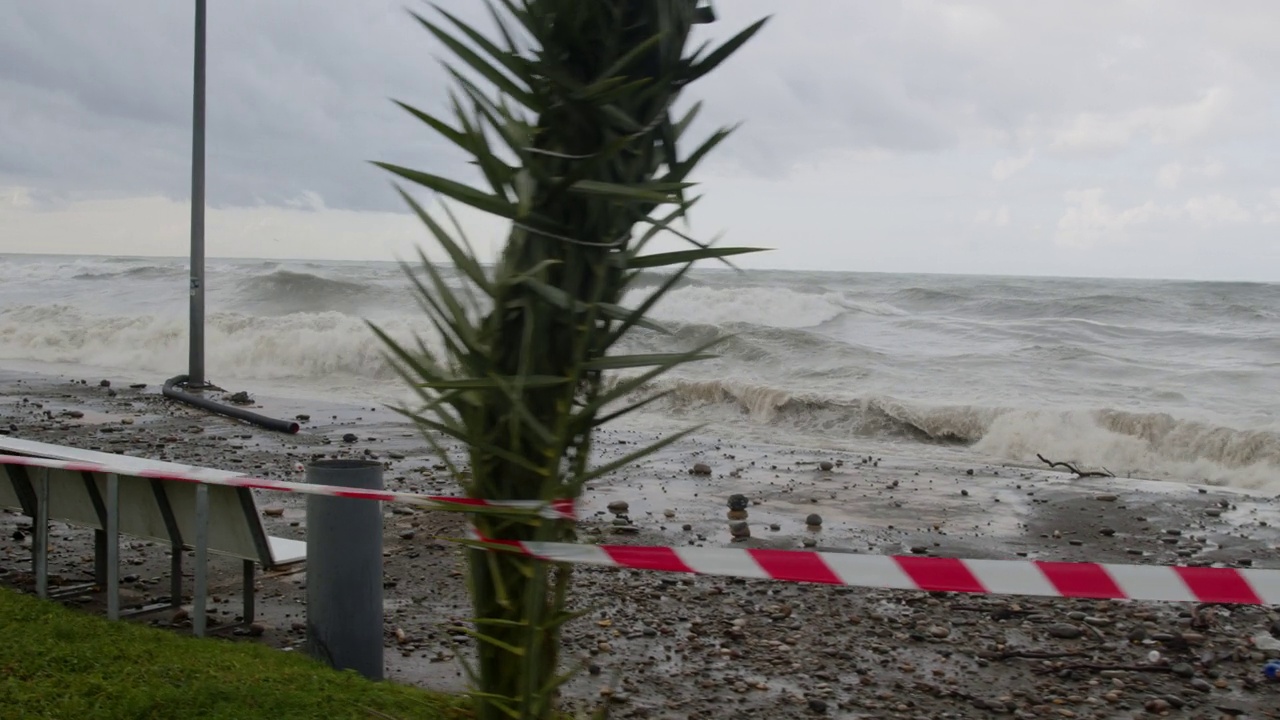 在极端的暴风雨天气中，海浪冲击着被摧毁的道路和海岸线视频素材