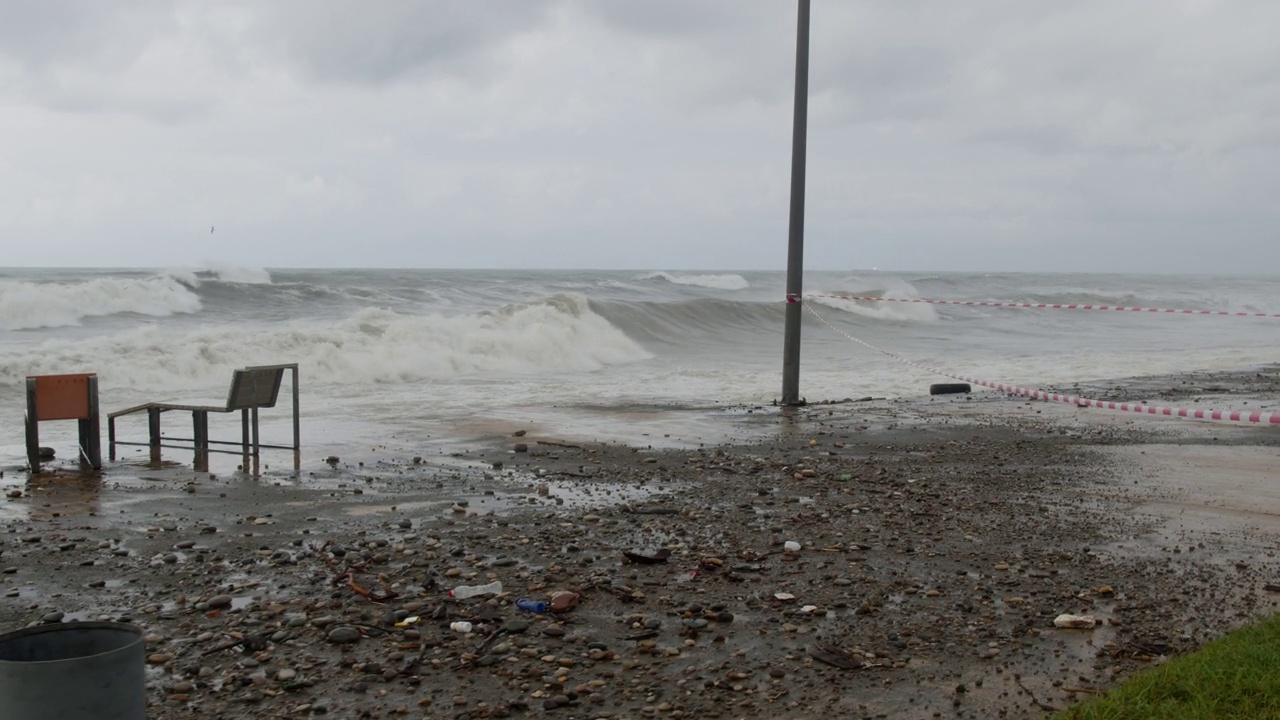 在极端的暴风雨天气中，海浪冲击着被摧毁的道路和海岸线视频素材