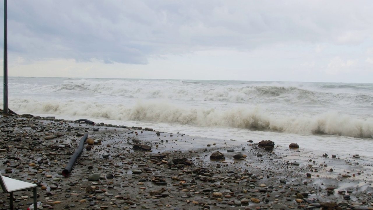 在极端的暴风雨天气中，海浪冲击着被摧毁的道路和海岸线视频素材