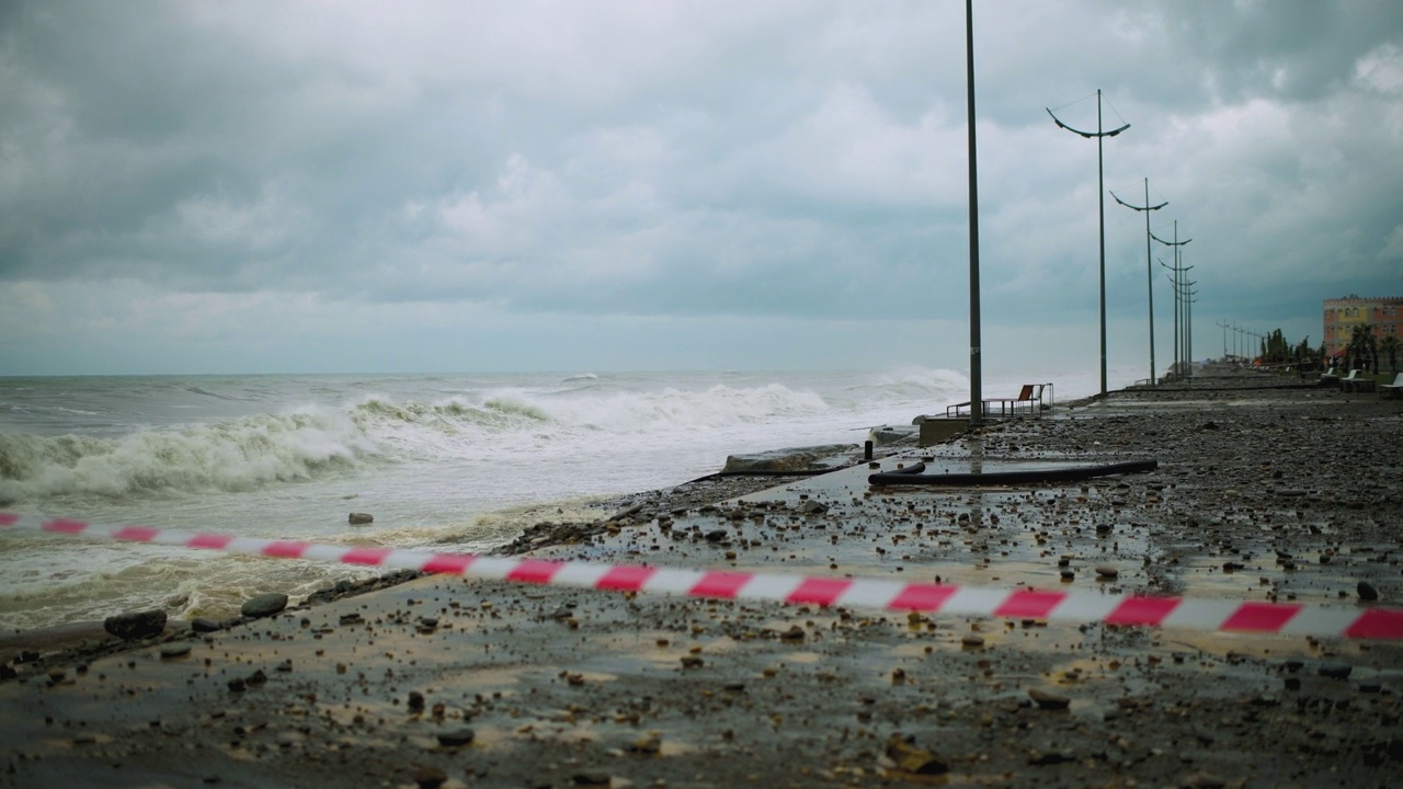 在极端的暴风雨天气中，海浪冲击着被摧毁的道路和海岸线视频素材