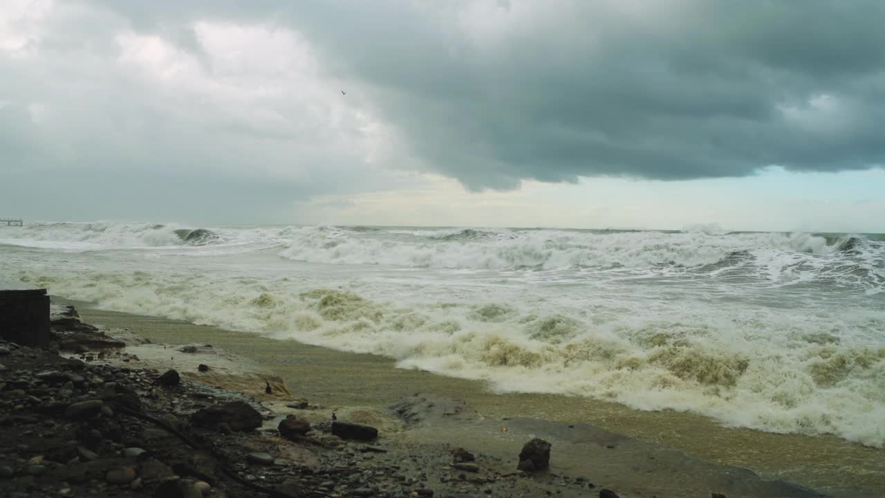 在极端的暴风雨天气中，海浪冲击着被摧毁的道路和海岸线视频素材