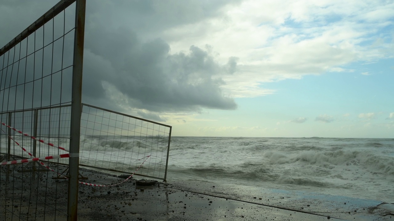 在极端的暴风雨天气中，海浪冲击着被摧毁的道路和海岸线视频素材