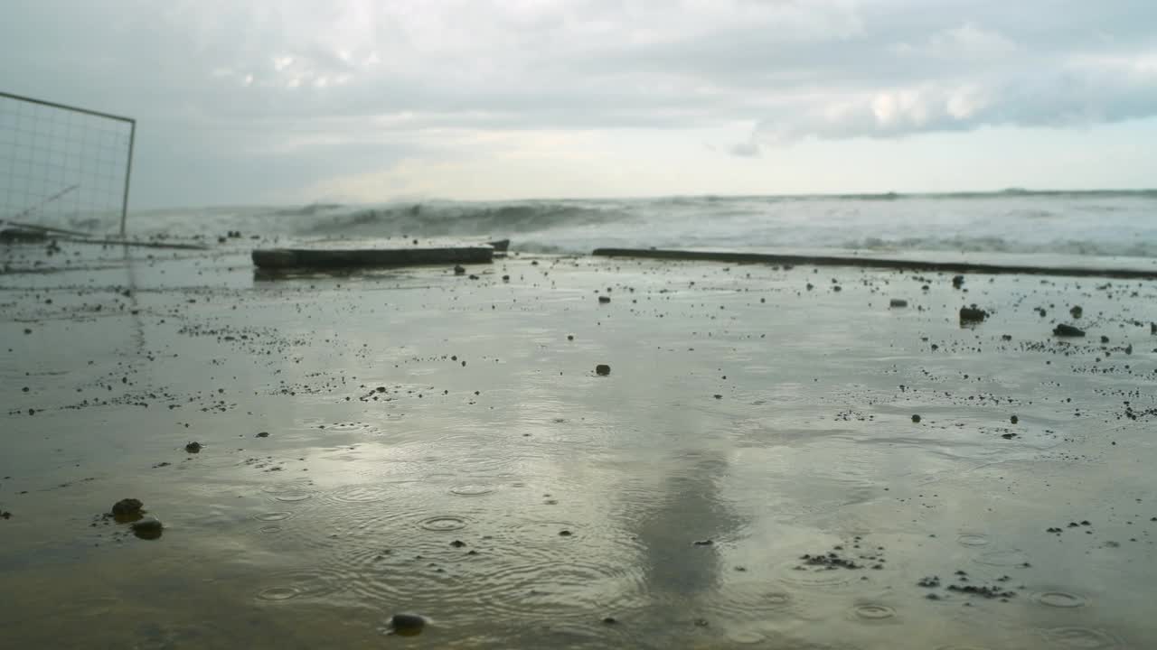 在极端的暴风雨天气中，海浪冲击着被摧毁的道路和海岸线视频素材