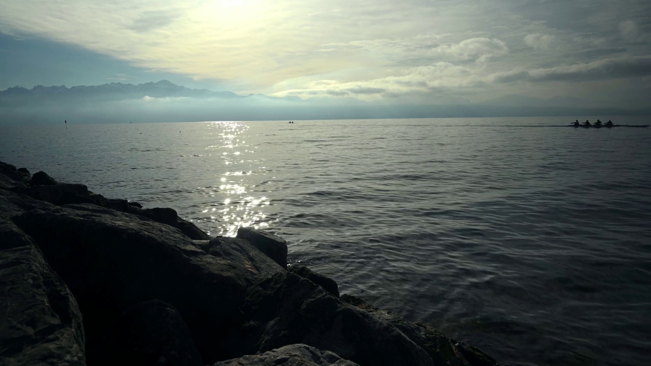 水上赛艇队身后的朝阳。日内瓦湖的风景，天空和云。视频素材