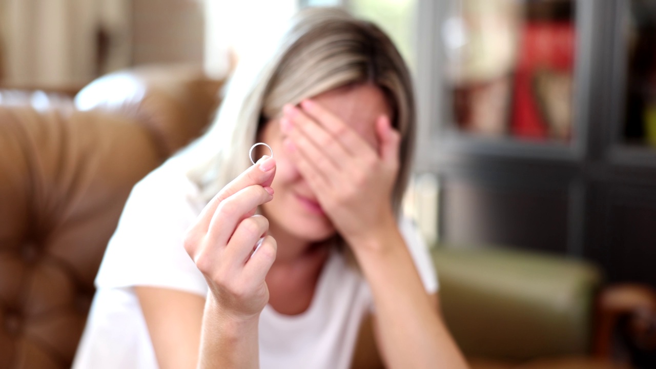 不开心的女人拿着结婚戒指特写视频素材