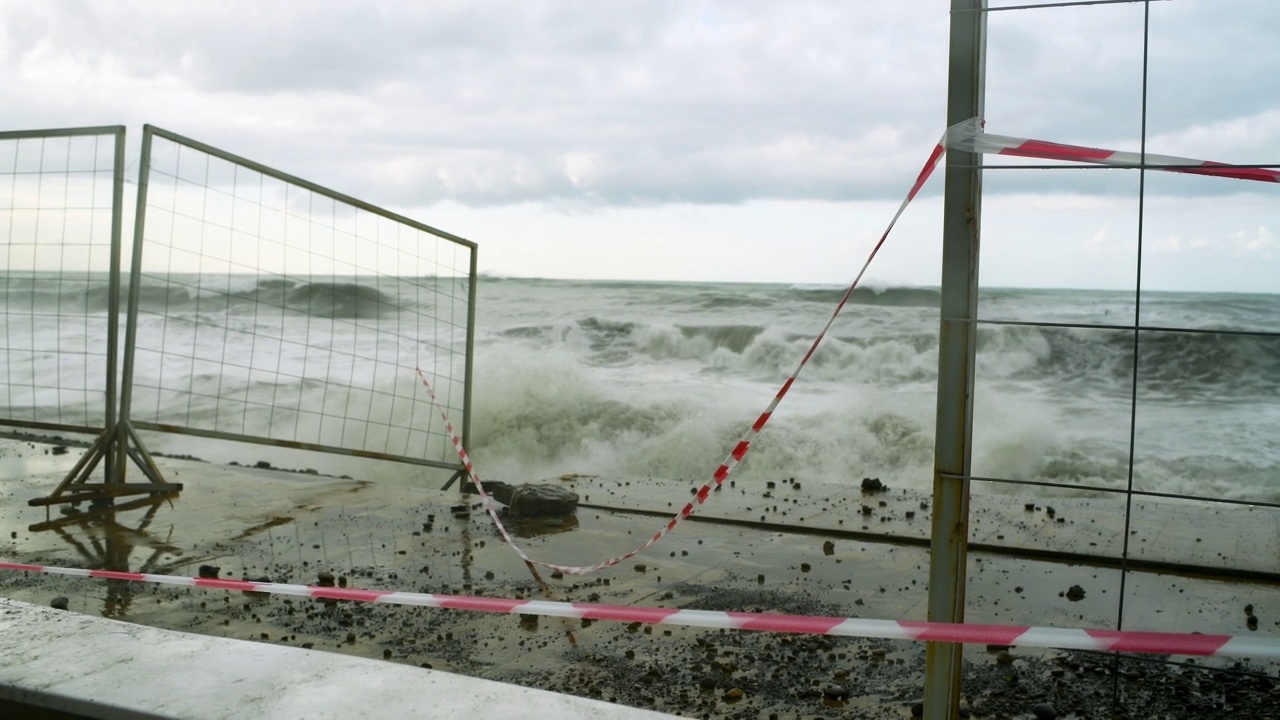 在极端的暴风雨天气中，海浪冲击着被摧毁的道路和海岸线视频素材