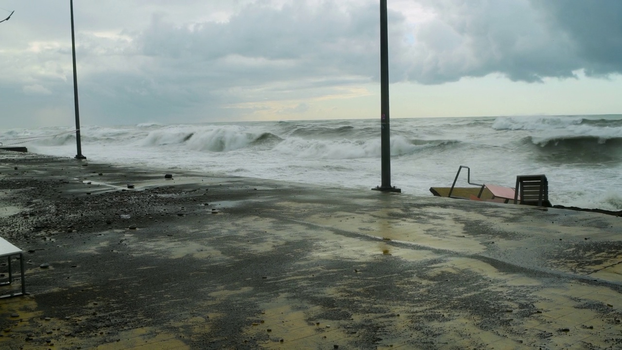 在极端的暴风雨天气中，海浪冲击着被摧毁的道路和海岸线视频素材