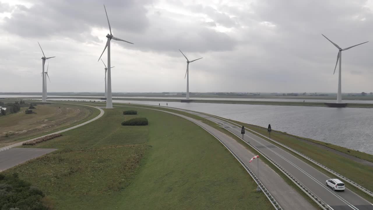 海景与运河，风力涡轮机和汽车在道路上移动/荷兰视频素材