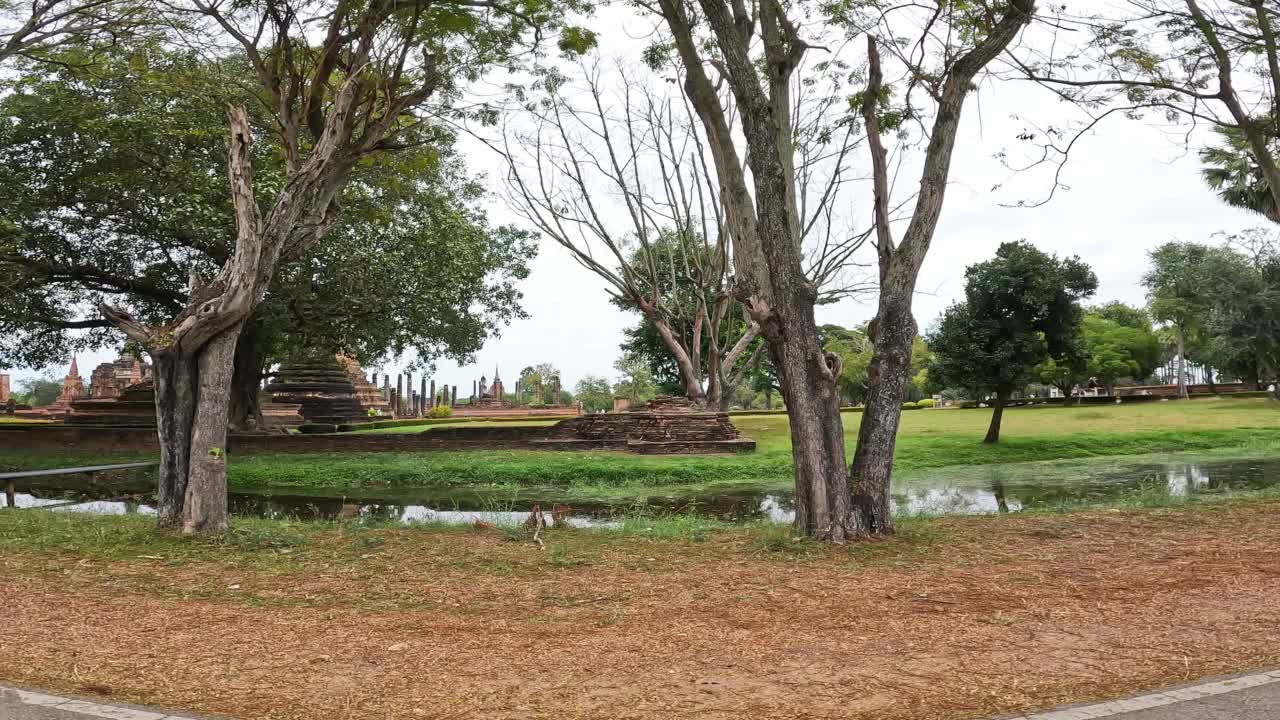 坐在旅游有轨电车上拍摄的Mahathat寺的景色。Mahathat寺是素可泰历史公园中最重要和最令人印象深刻的寺庙建筑群。视频素材